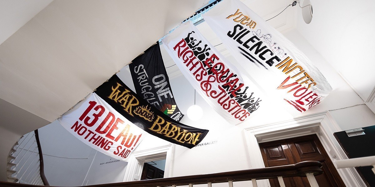 A canopy of protest banners suspended from the ceiling